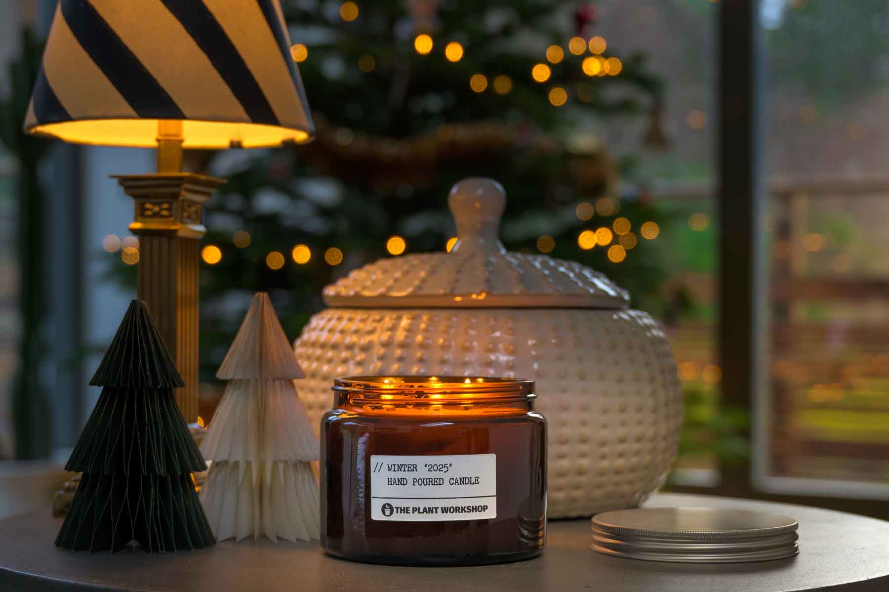 Winter Christmas candle by The Plant Workshop. Made in Scotland using eco-friendly ingredients with fast delivery across the UK. Christmas tree, fireplace, decorations, flickering candle and amber glass jar.